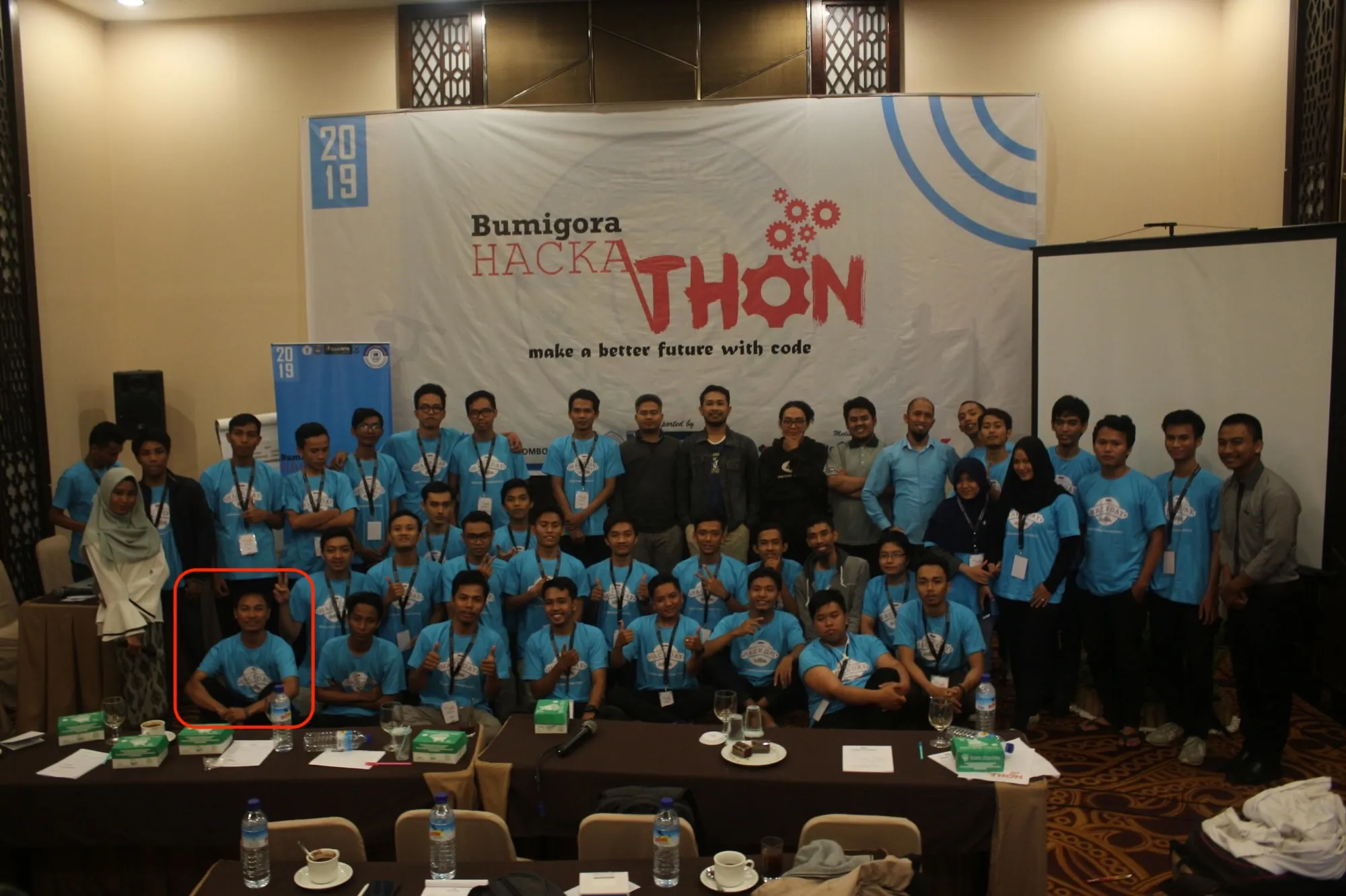 Participants and organisers of Bumigora Hackathon 2019 in front of the event banner
